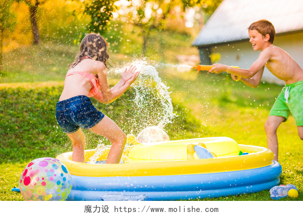 两个孩子在游泳池里玩耍男孩用水枪溅女孩 